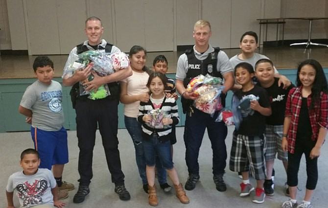 Lynbrook Elementary School students present “hug pillows” they made for Fairfax County Police officers to give to children at traumatic incidents such as car accidents.