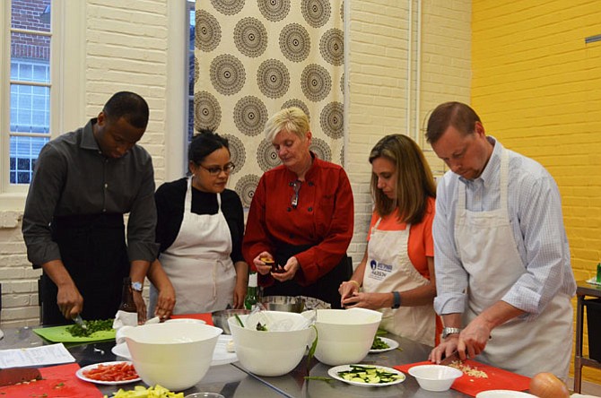 Knife skills are the first lessons taught in the kitchen at Date Night: Chef’s Table at the Lorton Workhouse Arts center. From left: Andre and Rose Prince of Reston, Chef Kathleen Linton and Kara and Christian McCarty of Burke.