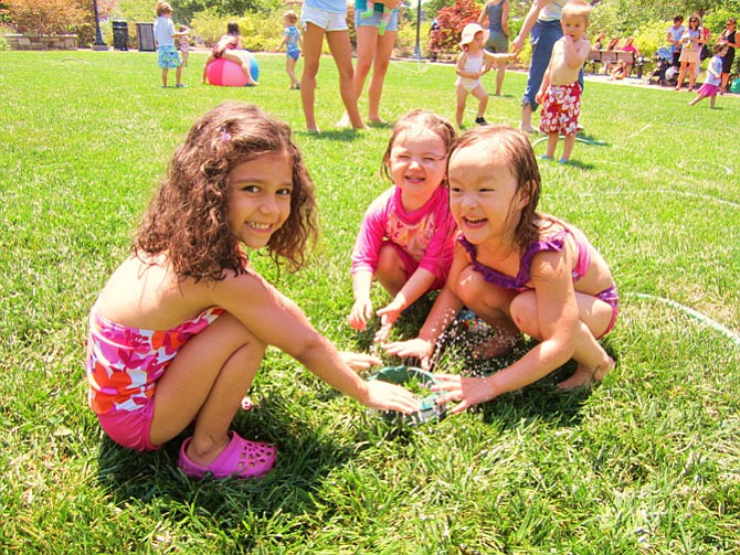 Stories and sprinklers on the Town Green draw younger children on hot, steamy days.
