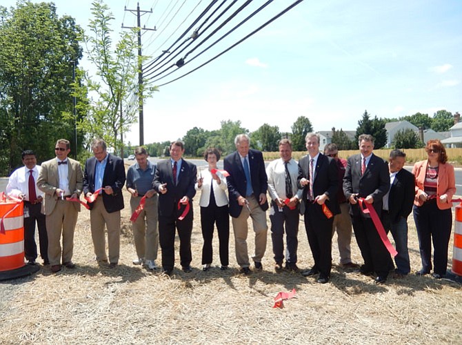 With the snip of several scissors, the ribbon is officially cut to mark the completion of Stringfellow Road’s widening. Bonnie Hobbs/The Connection