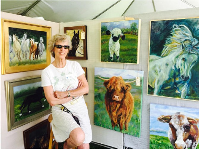 Artist Leslie Anthony poses with a few of her paintings for sale at last weekend’s Great Falls Studios art show on the Village Green Centre.
