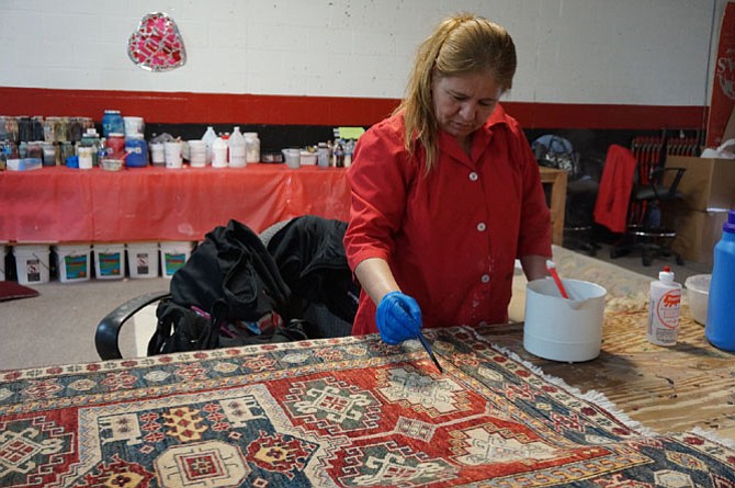 Candy Vargas does color restoration work on an antique rug at the new Hadeed Carpet and Rug Cleaning headquarters in Springfield.  The company was started in Alexandria in 1955 and will celebrate its 60th anniversary June 6.