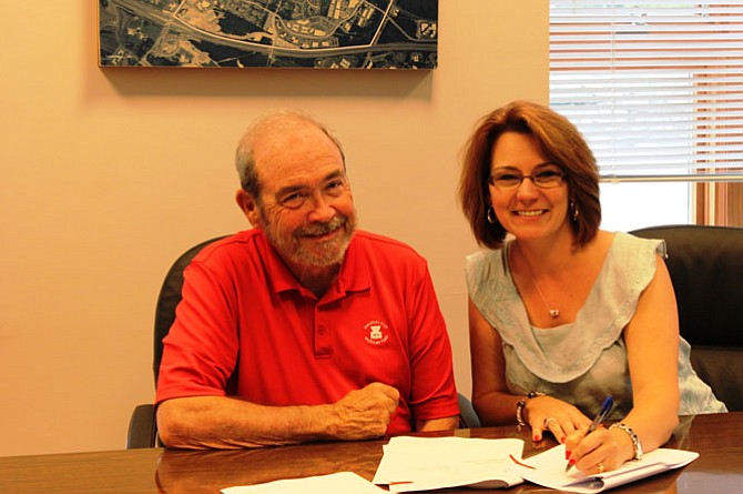 Mayor Lisa C. Merkel and Ronald K. Ashwell of Ashwell, LLC, the private holder of the land, sign a contract at the Herndon Municipal Center for Herndon to purchase 1.67 acres in Herndon’s historic downtown.
