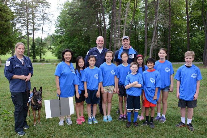 Members of the Fairfax County Urban Search and Rescue Task Force 1 who were deployed to Nepal following the earthquake included (rear from left) Elizabeth Chaney and rescue dog Ventoux, planning manager John Morrison and Ryland Chapman. They joined members of Meekha Mathema’s fifth grade class from Hunters Woods Elementary School in Reston in the Walk for Nepal earthquake victims: (front from left) Meekha Mathema, Annabel Lee, Summer Jakubowski, Caelin Rowell, Catherine Pak, Jake Hopp, Siddharth Kairpadi, Colin Simpson, Lauren Hannafin and Lindsey McNulty.