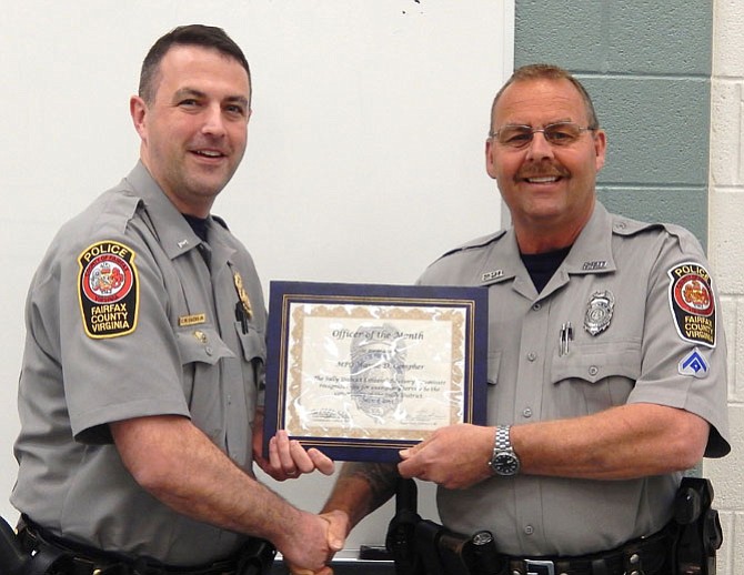 Lt. Matt Owens (left) presents an Officer of the Month certificate to MPO Wayne Compher.