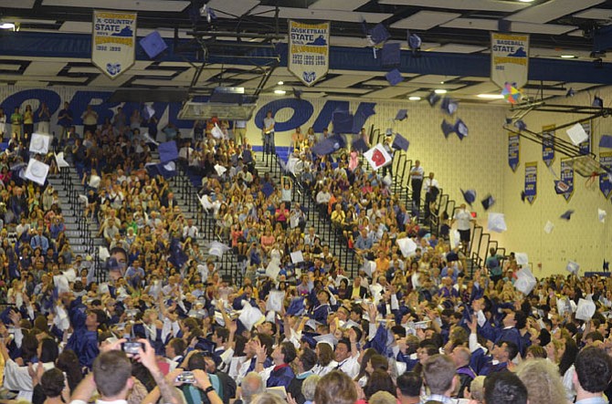 Woodson Class of 2015 toss their hats in celebration at the end of the ceremony.