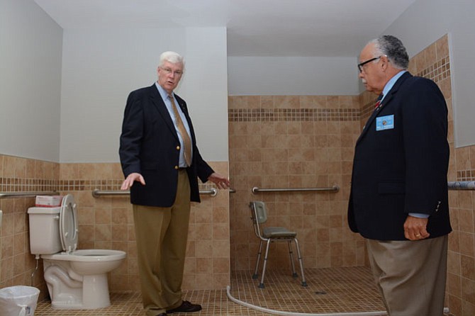 Marian Homes director William C Baker (left) and District 14 Warden for the Knights of Columbus Fidel Rodriguez tour one of the fully transformed bathrooms in the Queen of Peace house. 