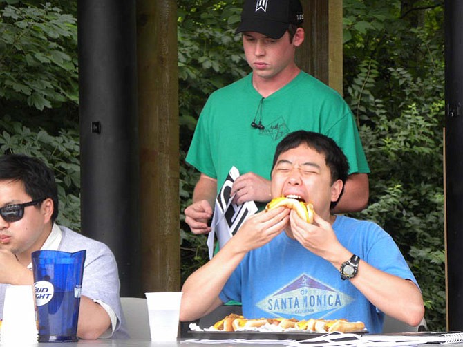 Paul Im, of Vienna, eats 10 chili dogs during a hotdog eating competition during the town of Vienna’s Fourth of July festivities. He lost to Vienna resident Thomas Jung, who bested him by eating 11.
