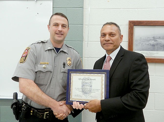 Police Lt. Matt Owens (left), the Sully District Station’s assistant commander, presents the Officer of the Month award to APO Tony Gul.
