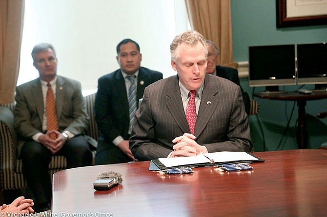 Photo of Virginia Governor Terry McAuliffe at the signing of the Transportation Network Company law (SB1025 and HB1662), signed in February. The law outlines regulations on vehicle registration and identification.
