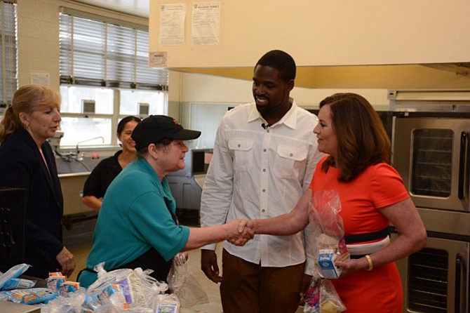 San Francisco 49ers wide receiver Torrey Smith (center) and First Lady of Virginia Dorothy McAuliffe (right) meet with some of the food preparation staff at Hollin Meadows Elementary School during a visit to the Summer Food Service Program.
