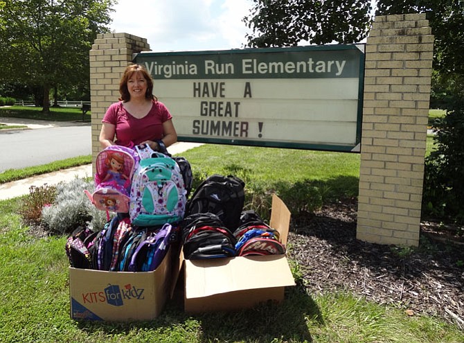 WFCM’s Jennie Bush delivers backpacks last summer to Virginia Run Elementary.