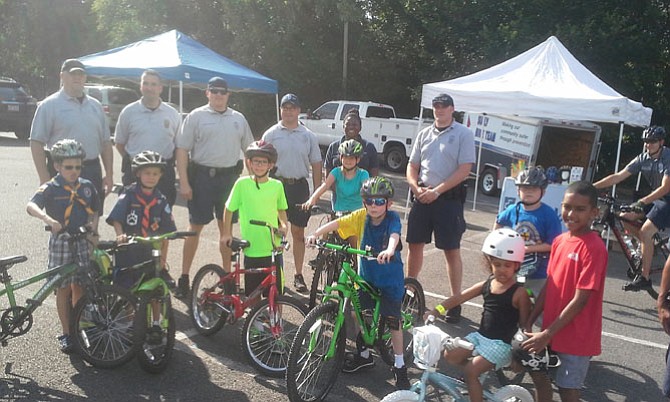 Fairfax County Police Officers, Linda Watkins from INOVA, and Cub Scouts with their siblings gather for a photo.