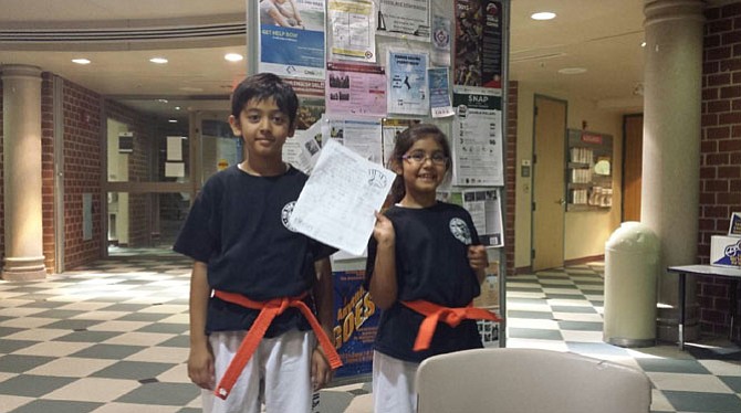 From left -- Akshat and Bhumi proudly display one of their summer reading logs.
