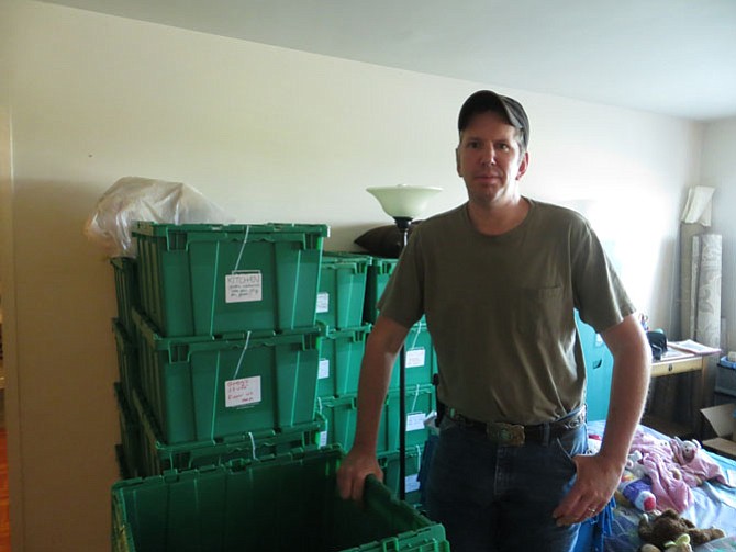 Greg Cain with the moving boxes in his family’s Hunting Point apartment.