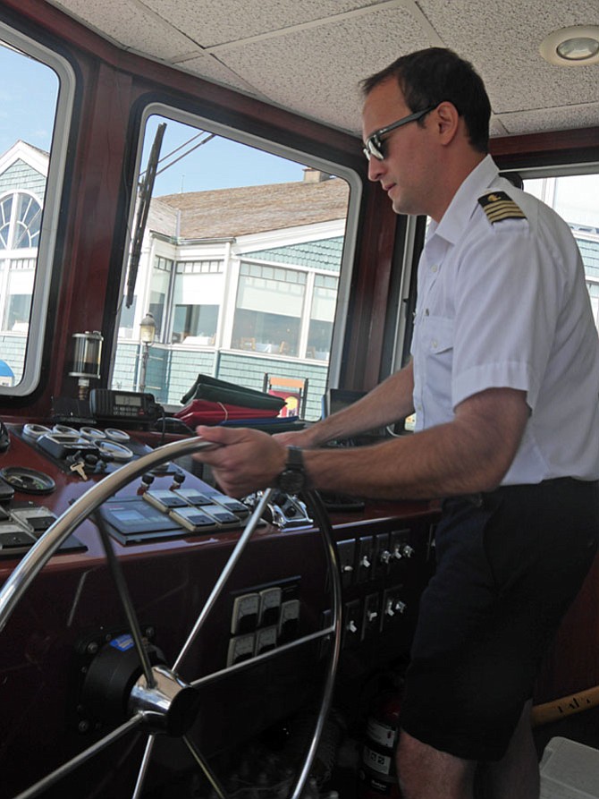 Alex Skubel flips the wheel and checks the gauges as he backs the water taxi out of the Port of Alexandria for the first trip of the day at 10:45 a.m. 