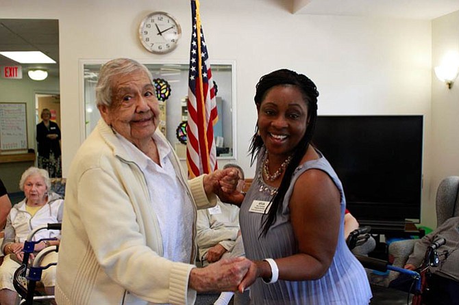 Margaret Estrada spends time with Afua Yankobah, an adult day health Care staff member at the Herndon Harbor Adult Day Health Care center. 
