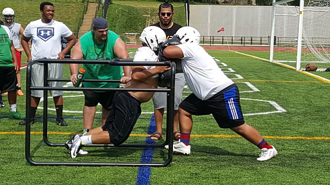 Wakefield rising senior linemen Anthony Tham, left, and Ryan Jones go through a drill during practice on Monday.