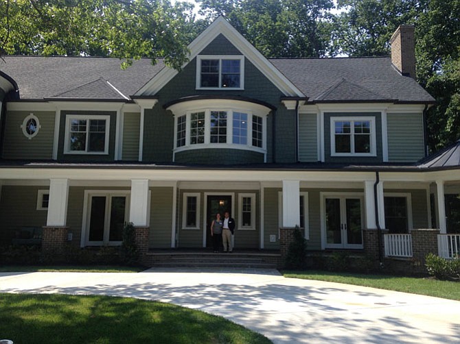 Tourette Syndrome Association of Greater Washington, D.C. Board member Tammy Starling and volunteer Michael Chow in front of the Home of Distinction at 8601 Nutmeg Court, Potomac. Through Aug. 9, the public is invited to tour this $3.9 million home to benefit the association. 
