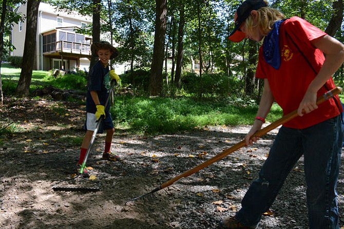 Dennis Hosken (left) of Springfield and Casey French (right) of Burke are members of Burke-based Boy Scout Troop 1965. They helped spread gravel to improve the trail that’s part of the Long Branch Stream Valley path.
