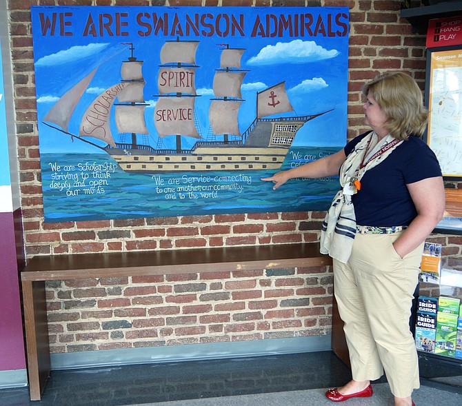 Principal Bridget Loft shows off a year-long art project situated in the lobby of Swanson Middle School, home of the Admirals. 
