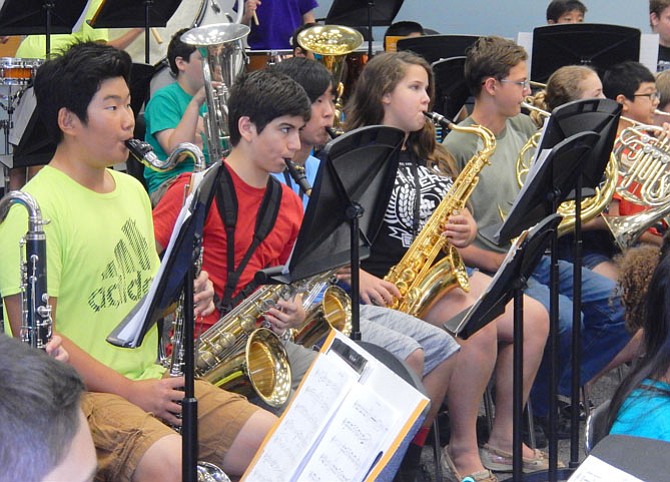 Students play saxophones and other brass instruments with the symphonic band.
