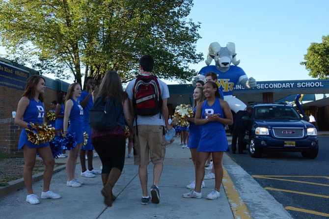Cheerleaders welcome students walking into their first day at Robinson Secondary School.