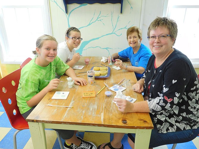 Having fun painting pottery together are (from left) sisters Kiara and Mikaela Fenn, grandmother Gloria Fenn and mom Molly Stephenson.
