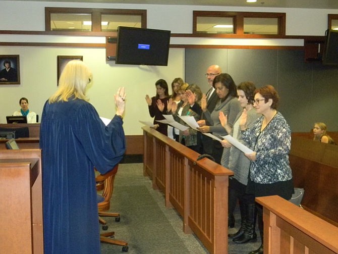 The Chief Judge of the Fairfax County Juvenile and Domestic Relations District Court, the Honorable Janine Saxe (left), administering the oath to the November 2014 class of Fairfax CASA Volunteers