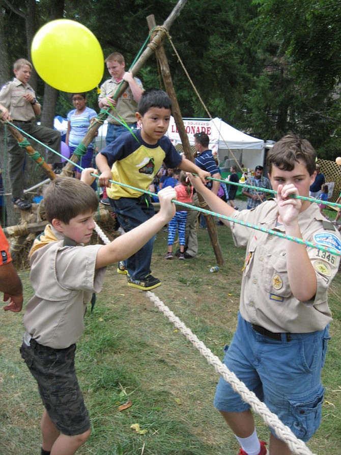 Walking across the Monkey Bridge at the 2015 Burke Centre Festival is Jean Pierre Portillo of Alexandria. The bridge was constructed by members of Boy Scout Troop 1345 of the Burke Centre Conservancy.