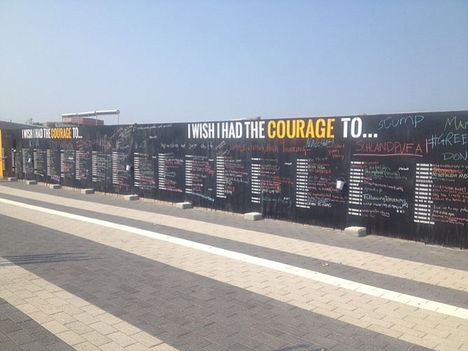 A chalkboard has been set up along construction fencing at the Wiehle-Reston East station, and encourages the public to write in an ending to the sentence, “I wish I had the courage to….” This art project closes Sept. 26.
