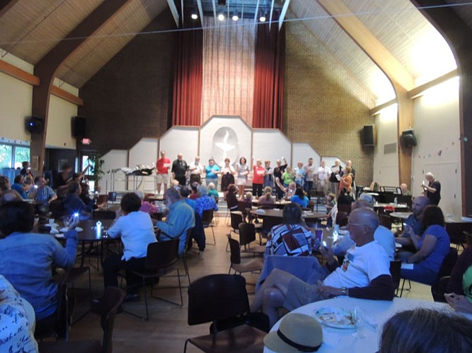 Mt. Vernon Unitarian Church members wave small lights during a song at their 60th anniversary.