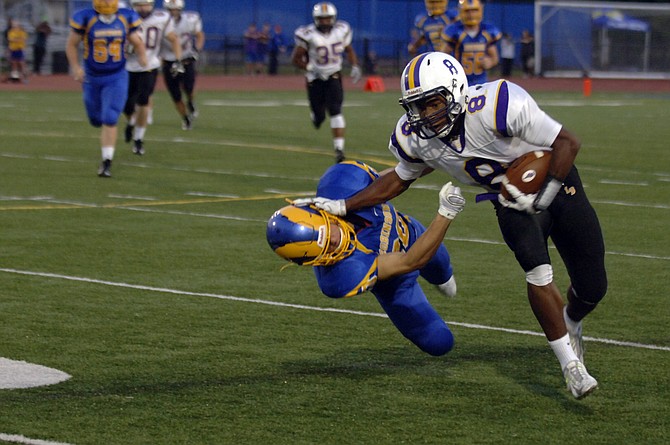 Lake Braddock running back Lamont Atkins stiff-arms a Robinson defender during the Bruins' 21-14 victory on Friday.
