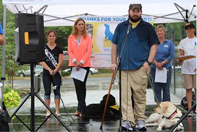 Capt. Gavin White (U.S. Army) and his assistance dog Stuart address the crowd at the Canine Companions for Independence DogFest Walk ‘n Roll on Sept. 12 in Arlington. Also pictured (from left) are 2015 Miss Maryland USA Amber Schroen; Honorary Event Chair Dr. Katy Nelson of “The Pet Show with Dr. Katy;” Canine Companions Northeast Region Executive Director Debra Dougherty; and DogFest Co-Chair Laura Clark.
