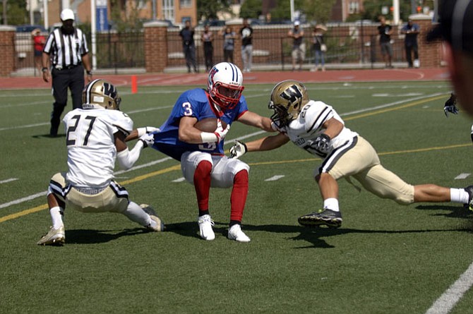 Tavon Greene (27), Bryson Malo (20) and the rest of the Westfield defense limited T.C. Williams to 12 yards of offense during Saturday’s 21-­6 Bulldog victory in Alexandria.