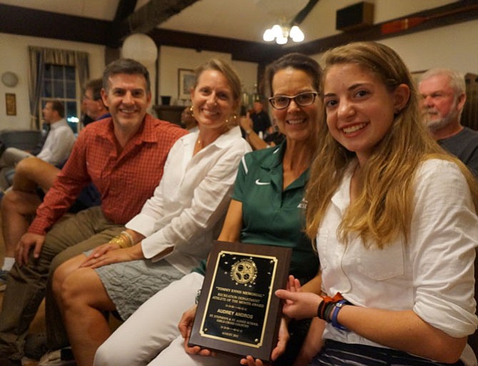 St. Stephen’s/St. Agnes cross country standout Audrey Androus, right, holds her Athlete of the Month Award. With her are her father Theo, mother Terry and coach Faith Laundry.
