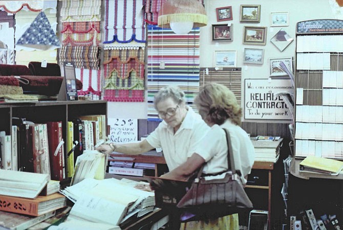 Color Wheel founder Nellie Boswell, circa 1979, helps a customer choose wallpaper.