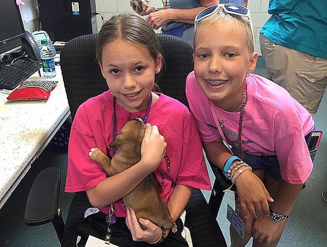 From left are Shelby Mysel and Tara Sankner with a puppy at the shelter.