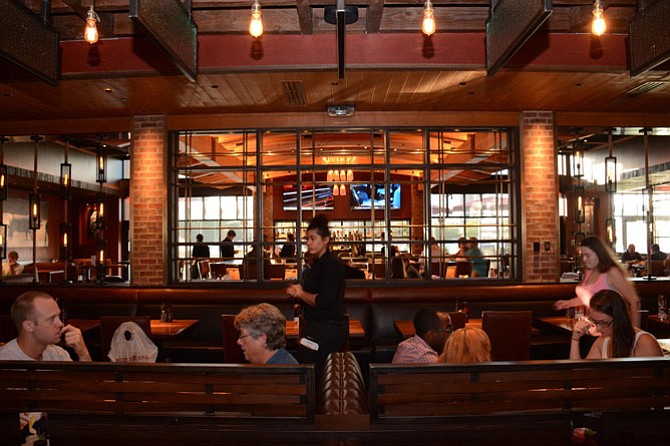 Sunlight streaming in from floor-to-ceiling windows contrasts with an interior palette of deep, earth tones at recently opened Wood Ranch BBQ & Grill in Springfield Town Center.