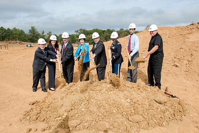 From left: Fairfax County School Board members Ilryong Moon (at-large) and Tammy Derenak Kaufax (Lee), Fairfax County Public Schools deputy superintendent Steve Lockard, Board of Supervisors chairman Sharon Bulova, U.S. Rep. Gerry Connolly (D-11), Fort Belvoir Garrison Commander Col. Michelle Mitchell, Mount Vernon School Board representative Dan Storck and Supervisor Gerry Hyland (D) toss the ceremonial first shovel of dirt at the Fort Belvoir Elementary School expansion ground-breaking on Sept. 28. 