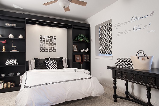 Careful planning and a unique wall bed system enable this room to function as a home office but hide the office aspect when being used for a guest bedroom. The center shelves slide to the side to cover office materials and reveal a drop-down queen size bed. 
