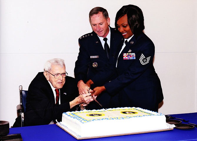 (From left) Col. Billy McLeod (retired) cuts the U.S. Air Force and Central Intelligence Agency birthday cake with Vice Chief of Staff of the U.S. Air Force Gen. David Goldfein and a young airman.