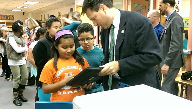 Del. Scott Surovell (D-44) checks out one of the laptop computers with a student at Bucknell Elementary School.