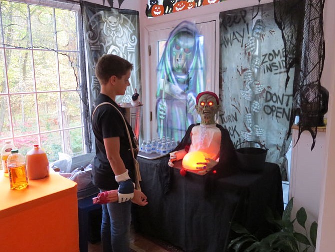 Neighbor Robert Folsom, 11, helps Jim Harris put the finishing “touches” on the haunts. 