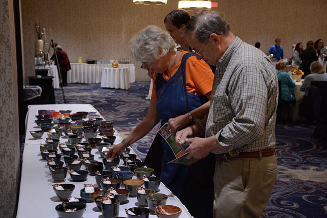 From left -- Fran and George of the Bryn Mawr area choose from handmade bowls at the Capital Area Food Bank Empty Bowls event held in Springfield on Oct. 29. 