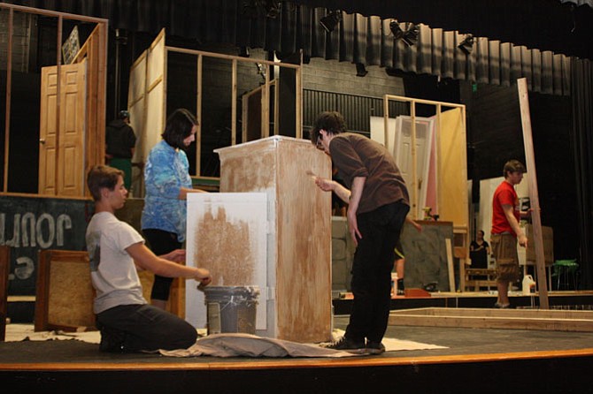 South County students prepare a piece of furniture for the three-story house set of the comedic play “Jabberwock.”