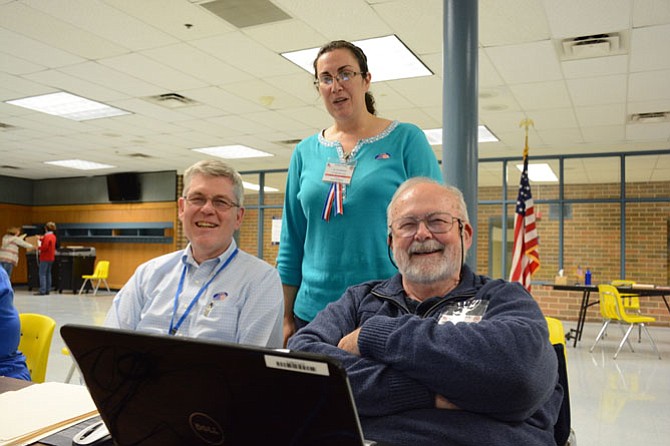 From left, election officers James Emery Jr of Fairfax, Teri Ayres of Fairfax and Merle Jacobs of Fairfax prepare to check in voters in the Robinson Secondary School cafeteria on Nov. 3.