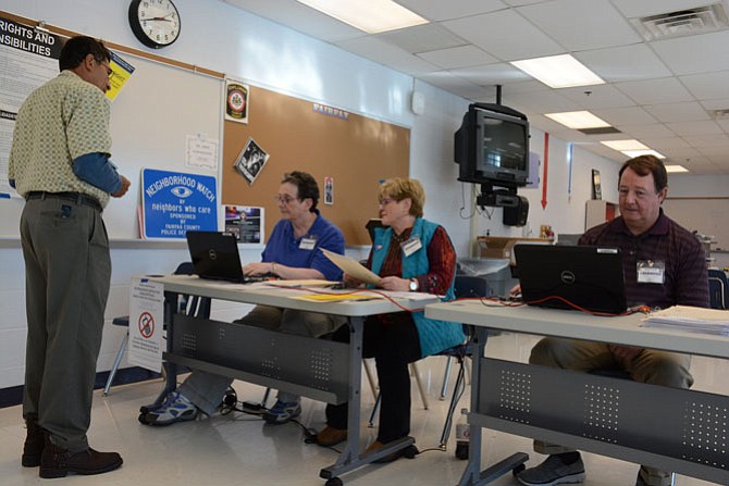 Election officers Lynda Hergenrather, Peggy McLeland and Phil Gbur of Mount Vernon sign in voters as they enter the West Potomac High School polling location.