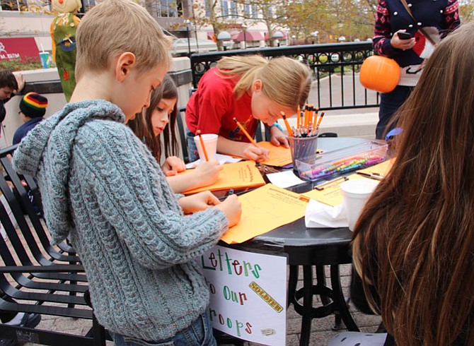 Children write to troops overseas during Dr. Stephan Tisseront’s 10th Annual Halloween Candy Buy-Back event on Monday, Nov. 2.
