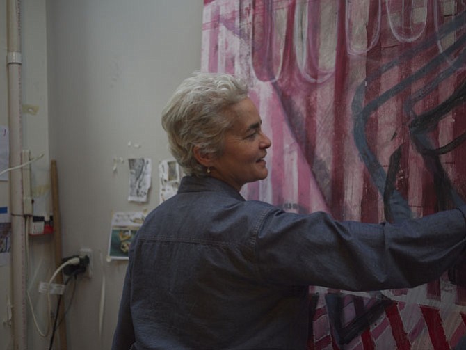 Sue Grace at work in her studio, with one of her paintings for upcoming exhibition. 
